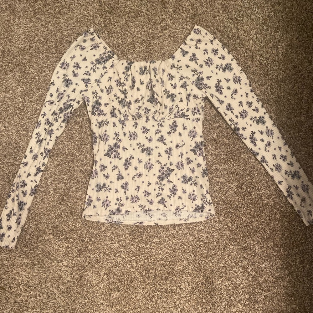 Creme colored girls blouse with a lavender and light green floral design.